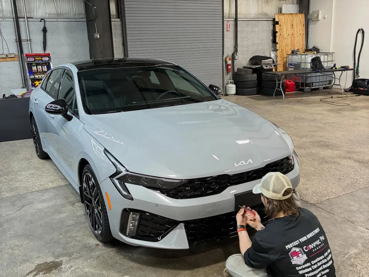 Maryland Clean Rides technician applying ceramic coating to the front of a gray Kia K5 in Hanover, PA